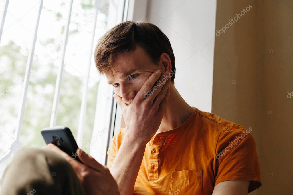 Frustrated young handsome men feeling upset desperate talking on the phone listening bad news about financial crisis