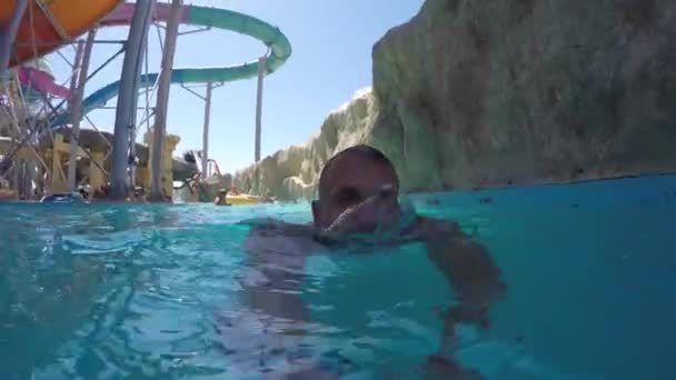 Homme athlétique caucasien nageant dans une rivière artificielle au parc aquatique — Video