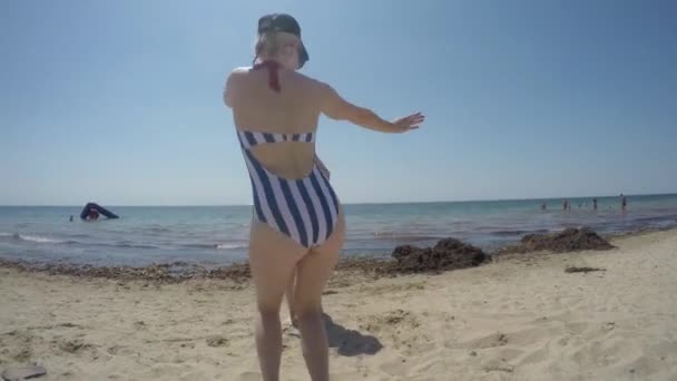 Két szőke lány táncol és szórakozik a parton a napsütéses napon. — Stock videók