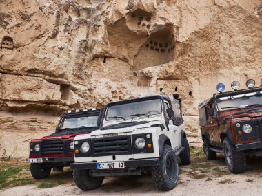 Goreme, Türkiye - Ekim 2019. Üç Land Rover off-road arabası kapadokyacı mağara evinin önüne park edilmiş.