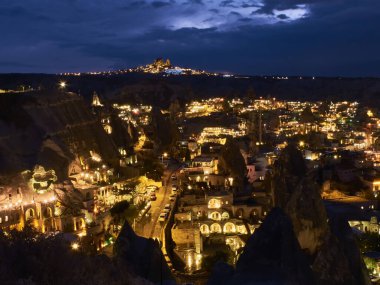 Kapadokya 'nın mağara evleri ve volkanik manzarası Goreme kasabası ve Uchisar kalesi gece ufkunda