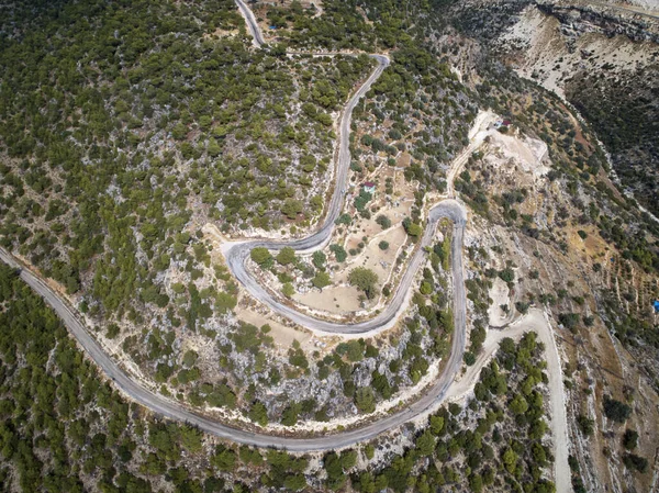Un sinuoso camino de asfalto serpentino de montaña. Vista aérea de arriba hacia abajo — Foto de Stock