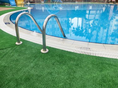 Yüzme havuzu ve yeşil halı.