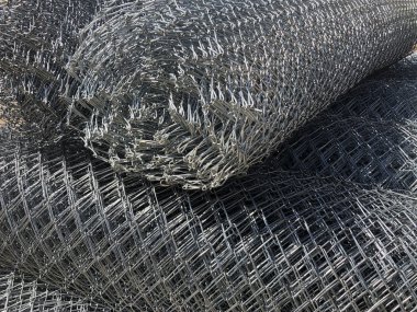 Zincirli tel örgü. Metal ağlar rulolara sarılmış.