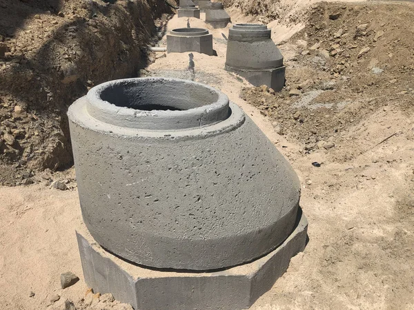 Drenagem de água da tempestade poços de concreto armado na trincheira escavada. Sistema de drenagem de água em construção — Fotografia de Stock