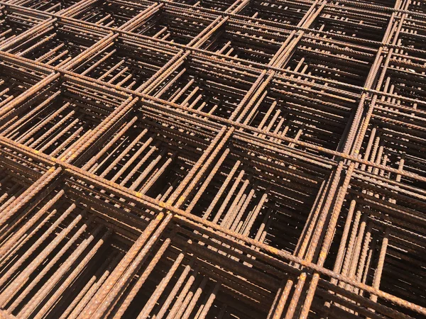 Piled iron reinforcement workpieces. Metal mesh for reinforcement. Iron rusty rectangular structure