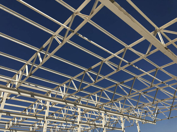 Truss ceiling and metal pillars and girders. Support constructions. Industrial building metal framework.