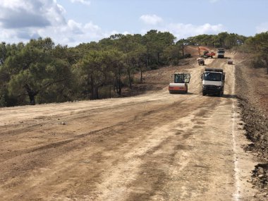 Highland Ormanı Yolu 'nun toprak işleri. Yol inşaatında farklı makineler kullanılıyor