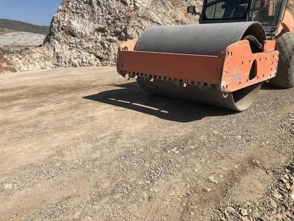 El rodillo vibrante comprime el suelo de una superficie de carretera durante las obras de construcción de carreteras — Foto de Stock