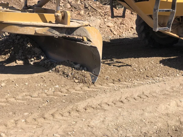 Close-up of moldboard planning road surface. Blade of motor grader during road construction works — Stock Photo, Image