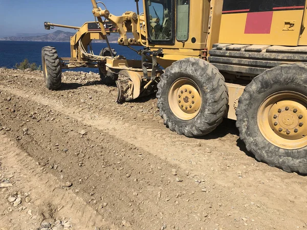 Pianificazione di una superficie stradale. Grader motore durante i lavori di costruzione di strade. Movimento terra, scavi, scavi — Foto Stock