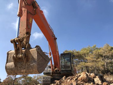 Yol inşaatı sırasında toprak yükleyen kazıcı kepçesi. Açı görüntüsünü yükle. Toprak hareketinde ağır makineler
