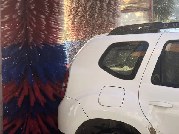 Αυτοκίνητο στο in-bay αυτόματο πλύσιμο αυτοκινήτων. Θολή κίνηση του περιστρεφόμενου πλύσιμο πολύχρωμα πινέλα. — Φωτογραφία Αρχείου