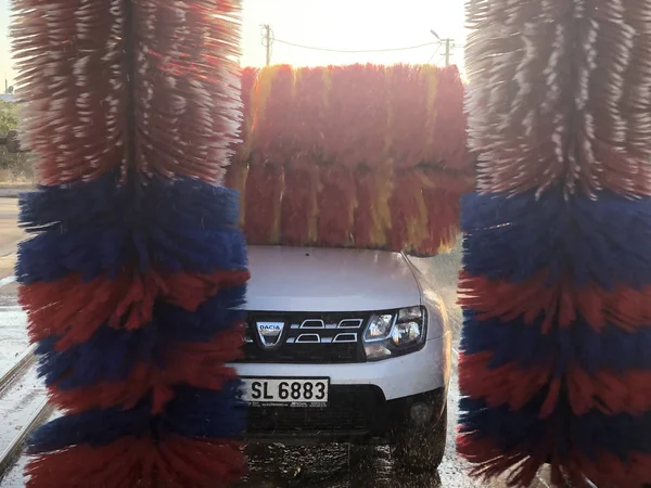 Bil i fack automatisk biltvätt. Suddig rörelse av roterande tvätt färgglada borstar. — Stockfoto