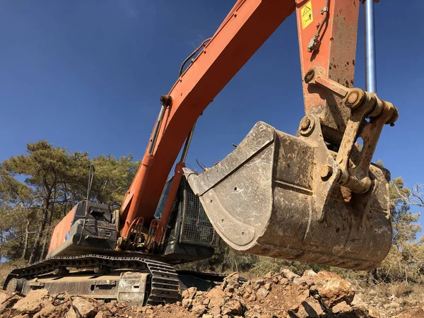 Excavator scoop loading a soil during road construction. Load angle view. Heavy machinery at earthmoving