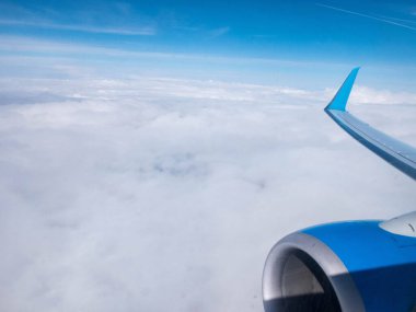 Bulutlar, açık mavi gökyüzü, uçağın motoru ve kanadı. Aydınlatıcıdan hava görüntüsü