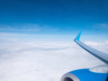 Bulutlar, açık mavi gökyüzü, uçağın motoru ve kanadı. Aydınlatıcıdan hava görüntüsü