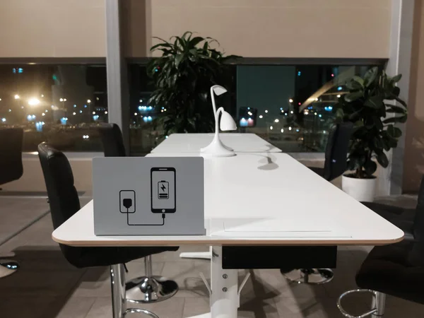 공항에서 코워킹 존. 흰색 책상, 검은 색 의자, 책상 상단에 장치 기호를 충전 — 스톡 사진