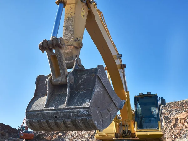 Excavatrice scoop pendant la construction de la route sur les sols rocheux — Photo