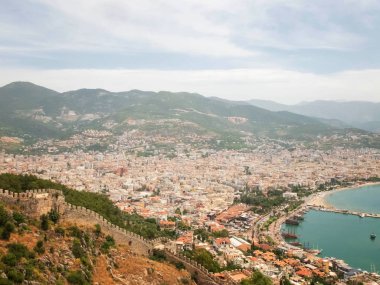 Alanya 'nın panoramik manzarası, limandaki deniz gemileri, Alanya Kalesi kale duvarı ve dağlar. Alanya, Antalya, Türkiye