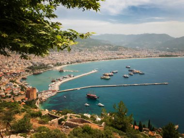 Alanya 'nın panoramik manzarası, limandaki deniz gemileri, Kizil Kule ve dağlar.