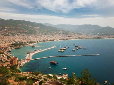 Alanya 'nın panoramik manzarası, limandaki deniz gemileri, Kizil Kule ve dağlar.