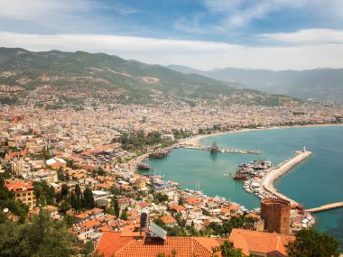 Alanya 'nın panoramik manzarası, limandaki deniz gemileri, Kizil Kule ve dağlar.