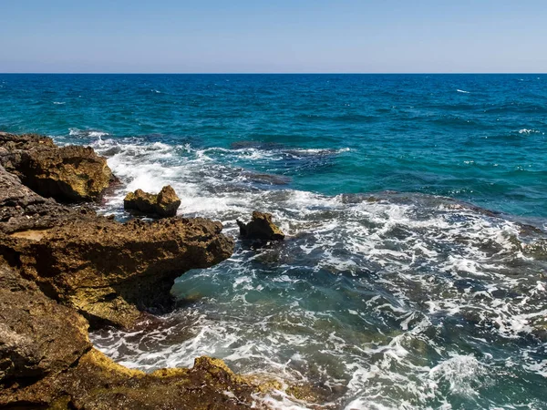 Las olas espumosas salpican a la costa rocosa. Mar Mediterráneo en Kizkalesi, provincia de Mersin, Turquía — Foto de Stock