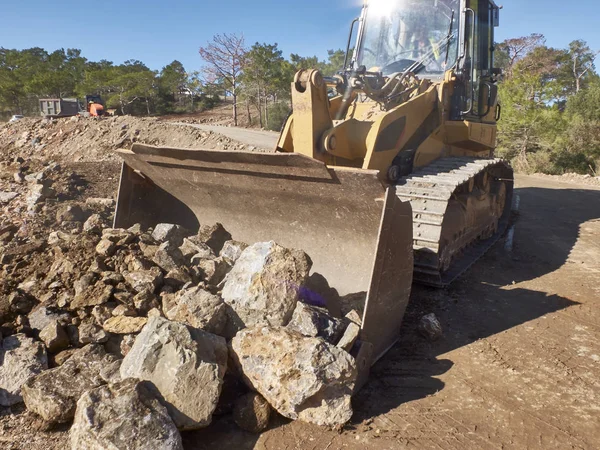Bulldozer è massi durante i lavori di costruzione di strade — Foto Stock
