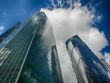 Moskova, Rusya - Eylül 2016. Moskova Uluslararası Ticaret Merkezi gökdelenlere karşı açık mavi gökyüzü ve bulutlar. Düşük açı görünümü