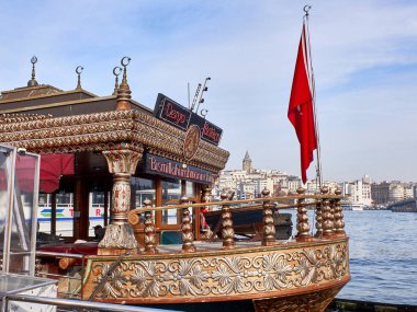 İstanbul, Türkiye - Aralık 2019. Arka planda Galata Kulesi 'nin karşısındaki Golden Horn körfezinde fast food tekneleri yüzüyor..