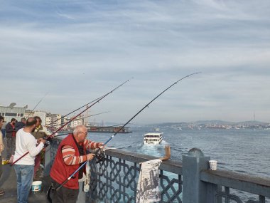İstanbul, Türkiye - Aralık 2019. Balıkçılar Galata Köprüsü 'nde balık yakalıyor