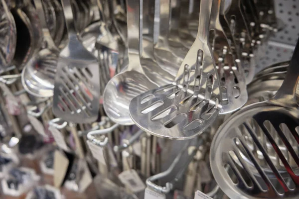 Chrome colored spoons and other different kinds of kitchenware