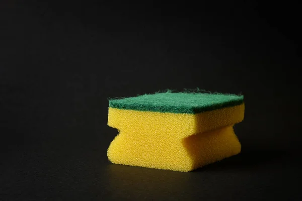 Única esponja amarela nova contra fundo preto — Fotografia de Stock