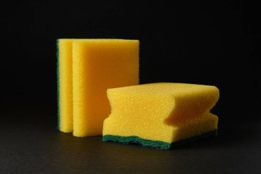 Siyah arka plana karşı iki yeni sarı sünger.