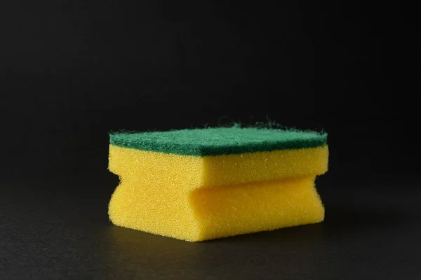 Única esponja amarela nova contra fundo preto — Fotografia de Stock