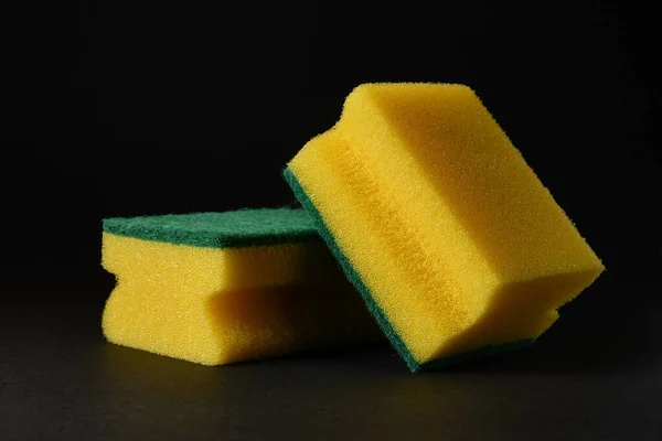 Duas novas esponjas amarelas contra fundo preto — Fotografia de Stock