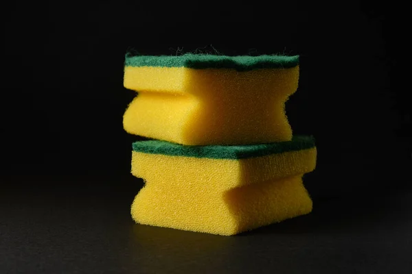 Duas novas esponjas amarelas contra fundo preto — Fotografia de Stock