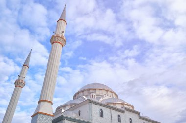 Bulutlu mavi gökyüzünün karşısındaki caminin minareleri