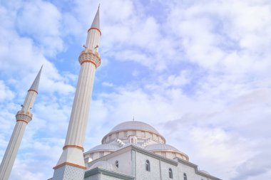 Bulutlu mavi gökyüzünün karşısındaki caminin minareleri