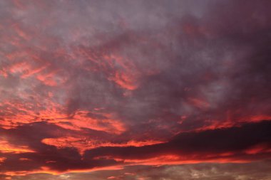 Batan güneşin ışınlarında dramatik bulutlu gökyüzü