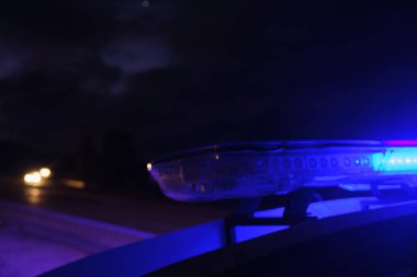 Polis arabasının gecenin karanlığında yanıp sönen ışıkları seçici odak