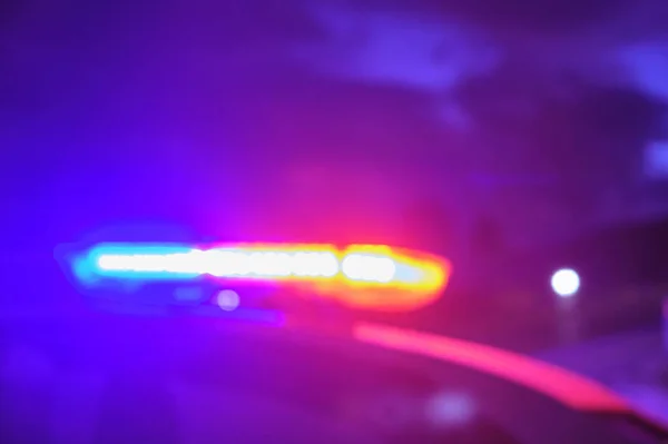 Polisen bil blinkande lampor i natten suddig selektivt fokus — Stockfoto