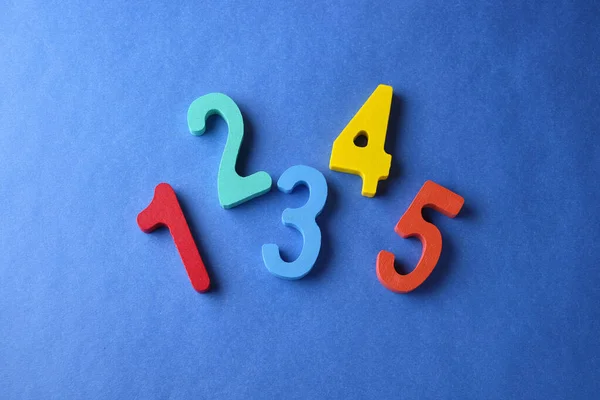 Multi colored toy numbers at blue background with copy space — Stock Photo, Image