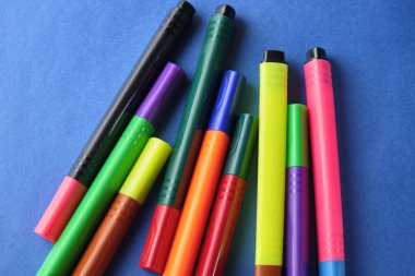 Mavi arkaplanda yanlış renk kapaklı çok renkli keçeli kalemler