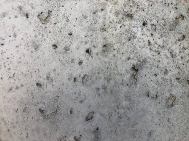 Mağaralar ve açıkta kalan çakıl taşlarıyla beton yüzey