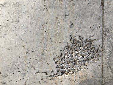 Mağaralar ve açıkta kalan çakıl taşlarıyla beton yüzey