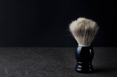 Siyah arkaplanda, taş yüzeyde tıraş fırçası
