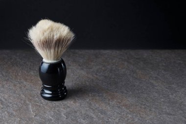 Siyah arkaplanda, taş yüzeyde tıraş fırçası