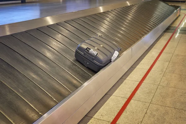 공항 수하물 짐수레의 러닝 머신에서 분실 된 여행 가방 — 스톡 사진